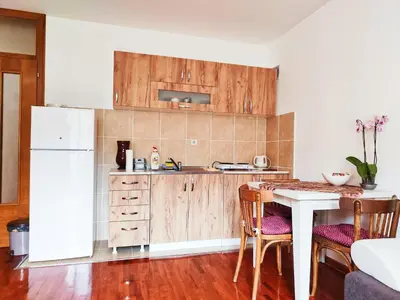 a kitchen with a table and a white refrigerator at Apartman 5ra in Vrnjačka Banja